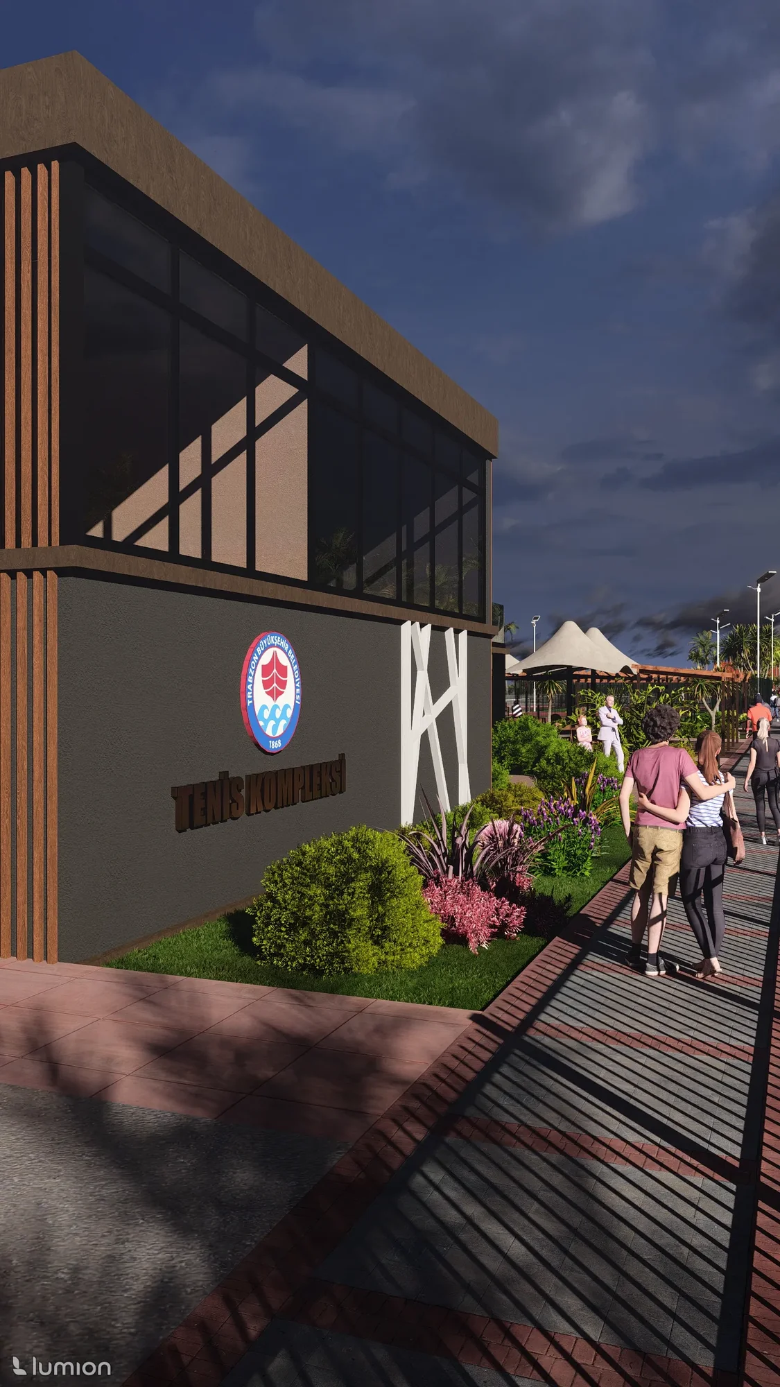 Kulüp binası girişinin yakın cephe çekimi. Trabzon Büyükşehir Belediyesi amblemi ve "Tenis Kompleksi" tabelası, yürüyen ziyaretçilerle
